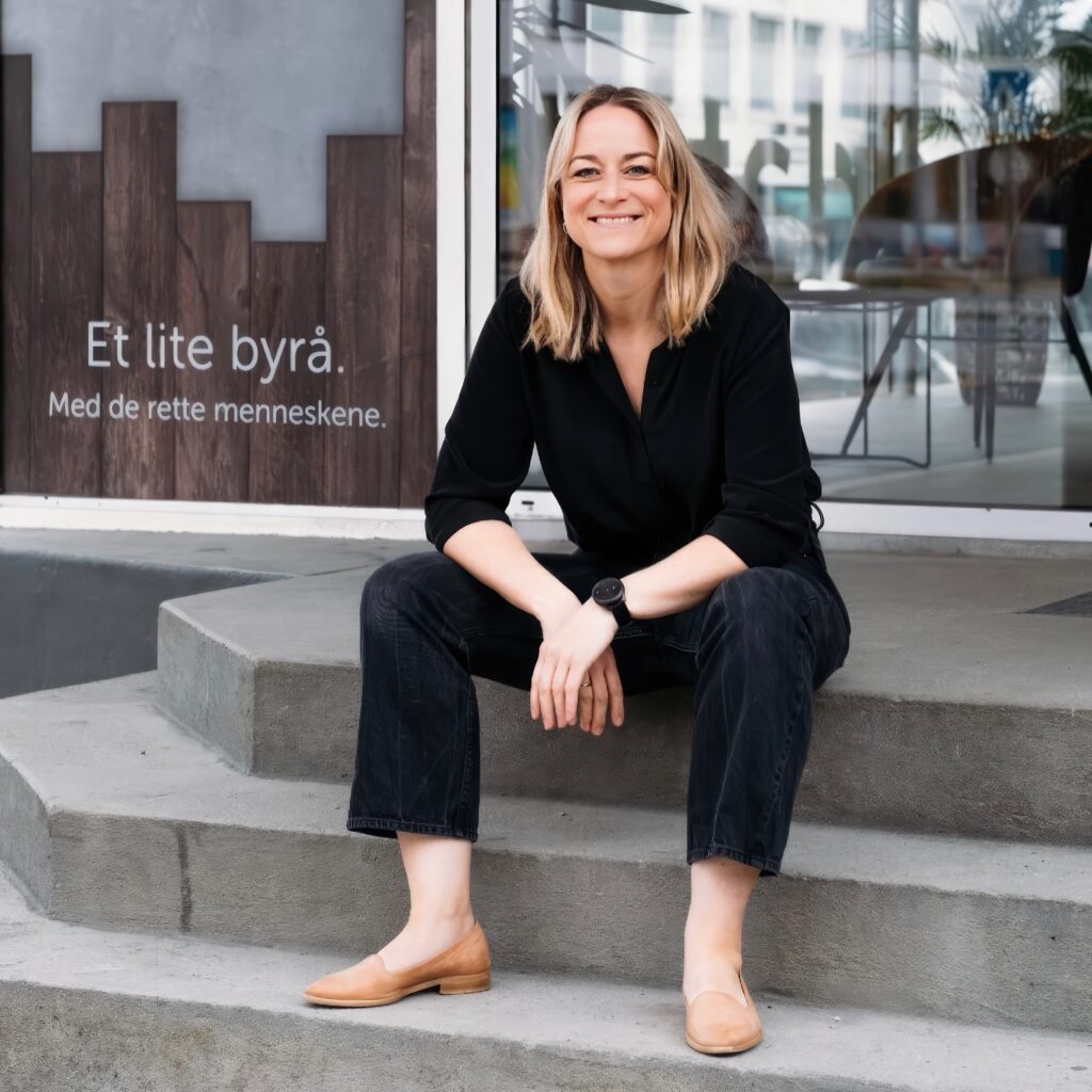 En kvinne sitter på en trapp utenfor et kontorbygg